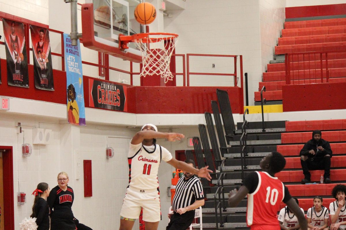 Manual's Ahmad Shelton (#11, 11) making a layup.