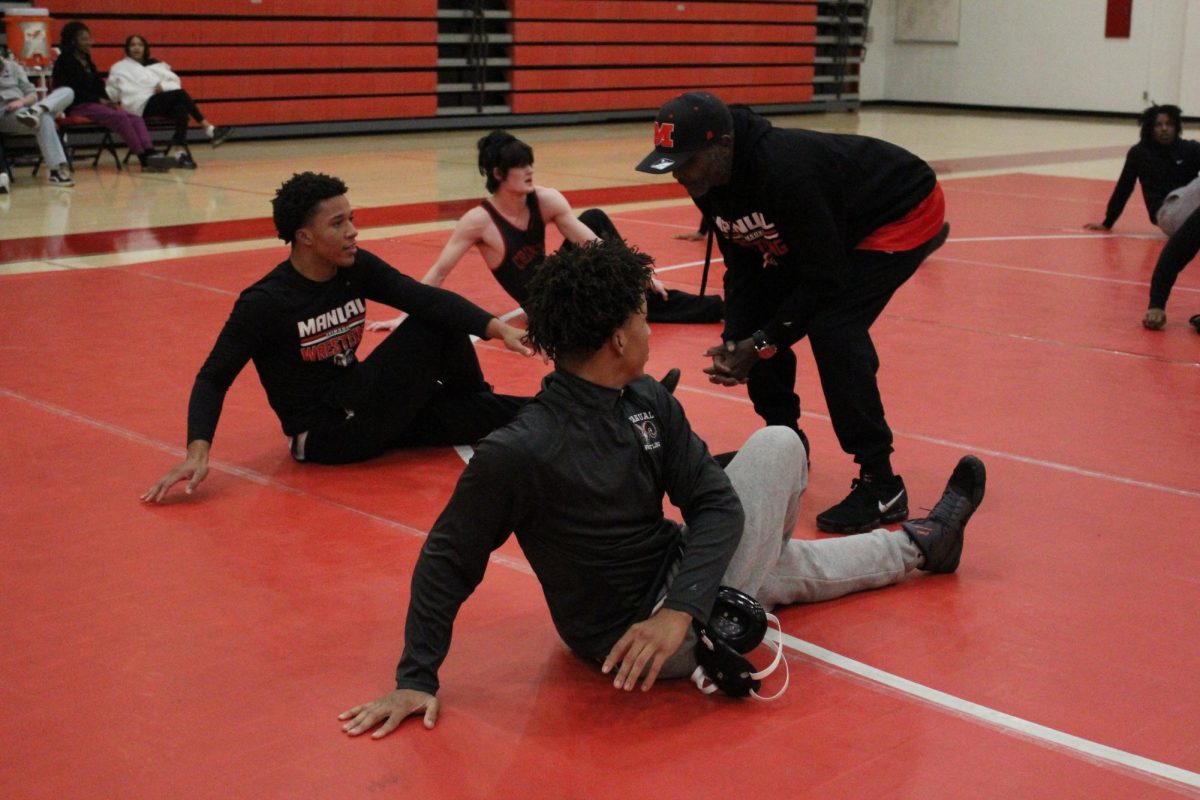 Devin and Darien Allen warm up and stretch prior to the start of a wrestling match last season. Photo courtesy of Christine Jolo.