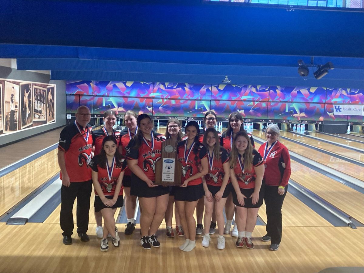 The girl's bowling team and coaches Ken Rowan and Corrie Rowan pose with the trophy on the lanes after the tournament. Photo courtesy of the Dikes  Family. 