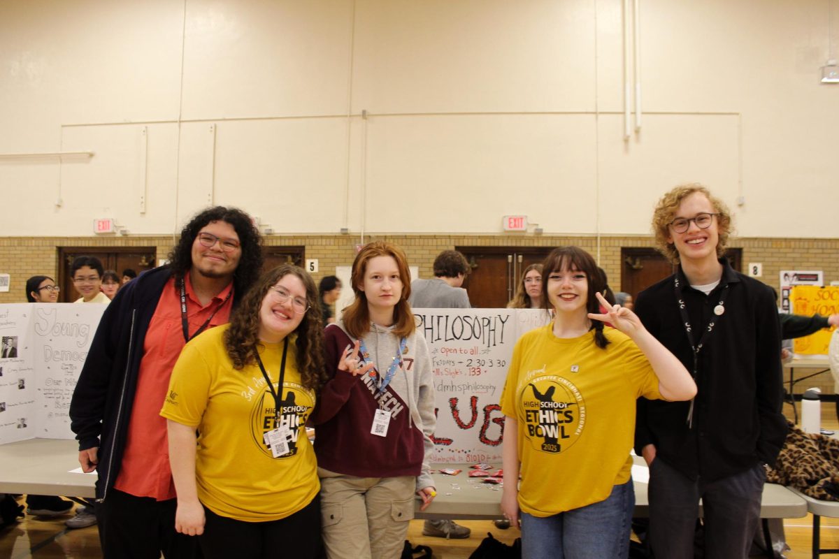 Philosophy Club officers and members posing in front of their poster board. 