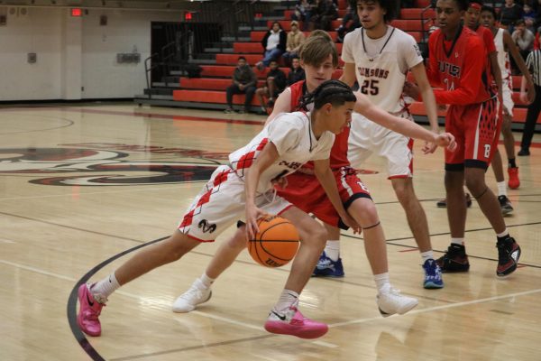 Dario Harper (#1, 9) dribbles past a Butler player.