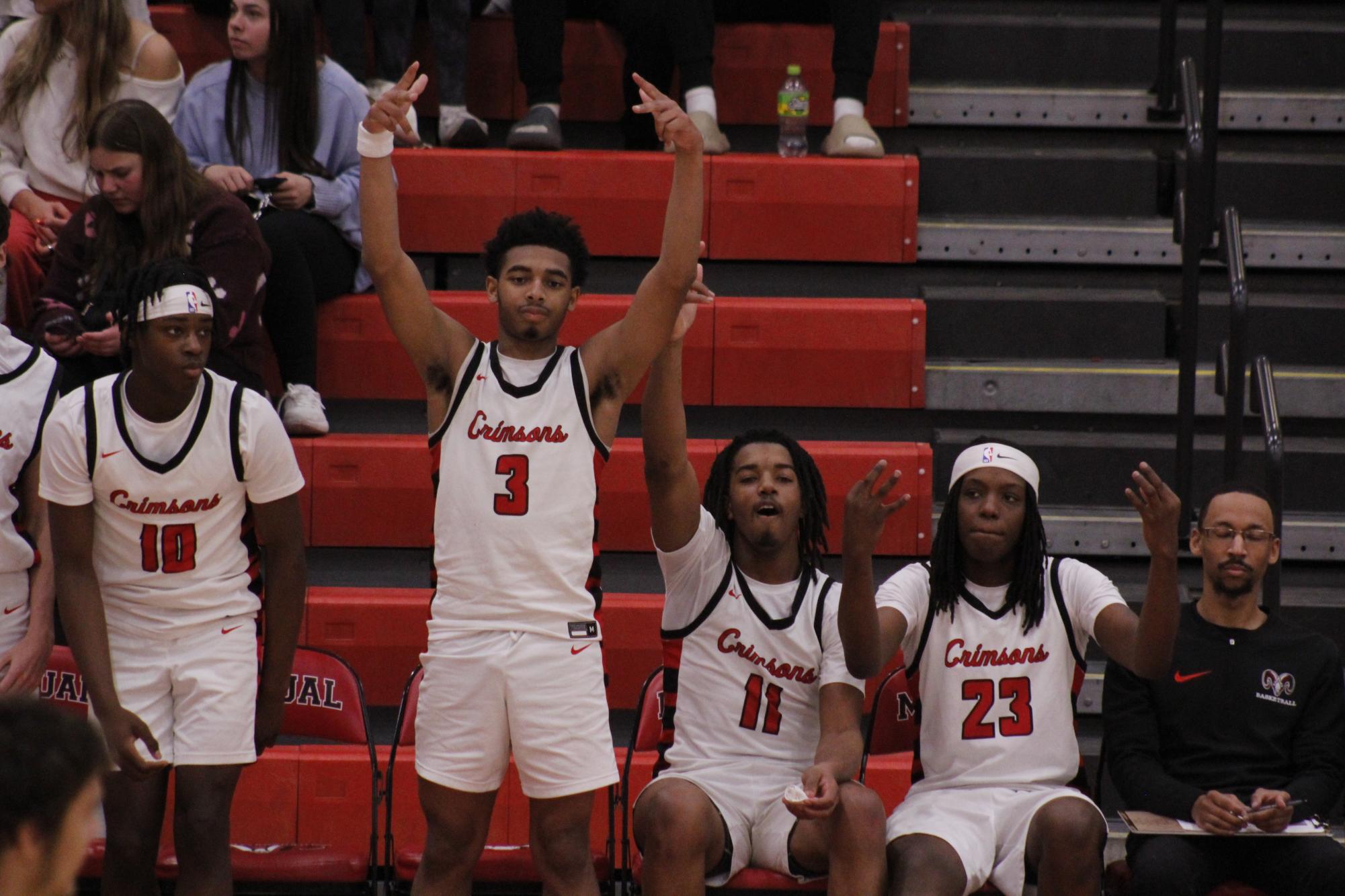 The team rises from the bench to celebrate a made three-pointer. 