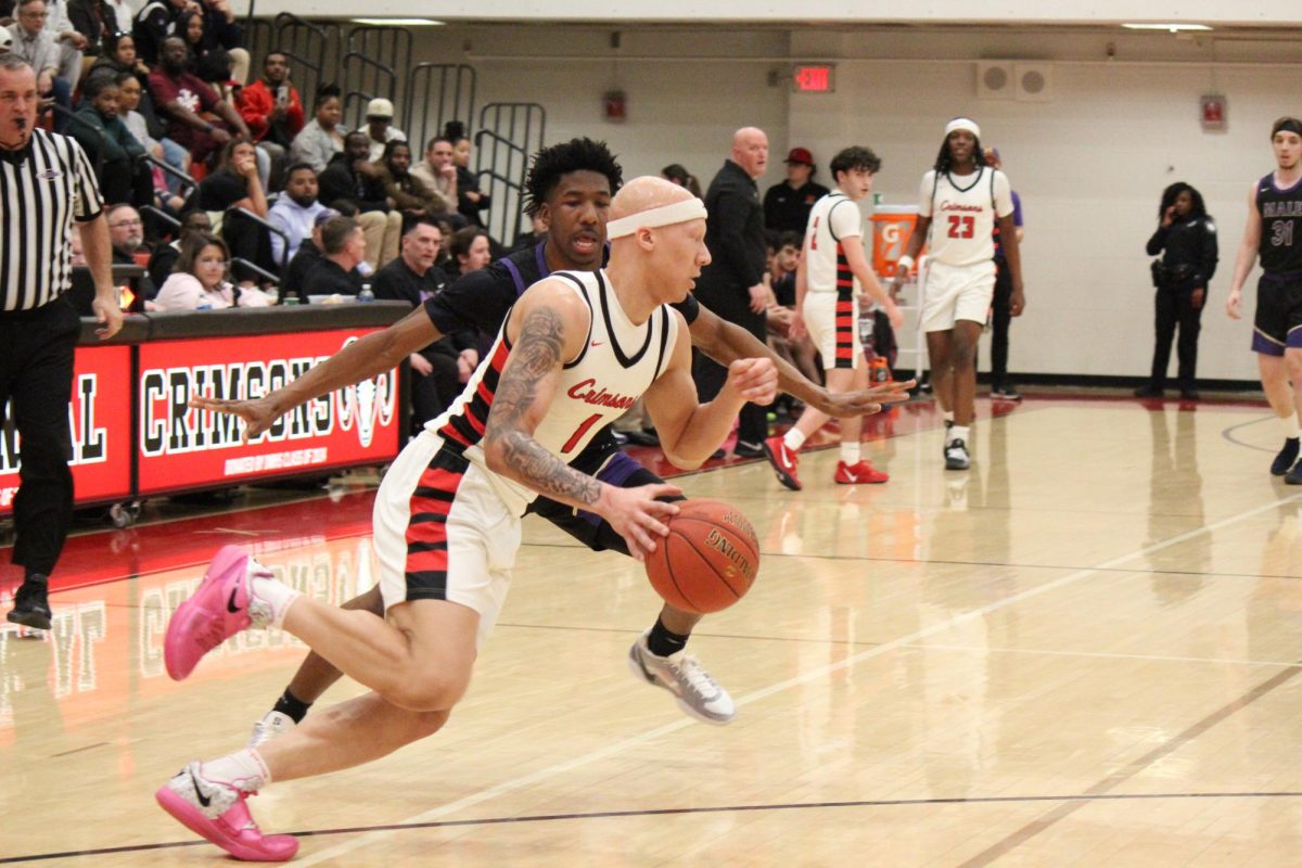 Justice Decker (#1, 12) dribbling around a Male defender.