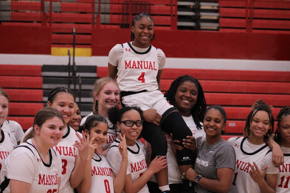 The team poses with Electra Lovely-Tolbert (#4, 12) on their shoulders after their victory.