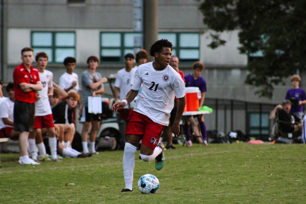Solomon Tandy (#21, 11) dribbles the ball down the field, looking for an open spot to shoot from.
