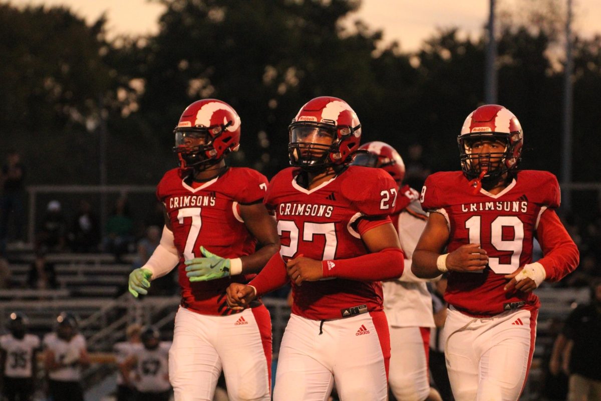Leslie Hall (#7, 11), Jamieon Williams (#27, 10) and Darien Allen (#19, 12) jogging off the field.
