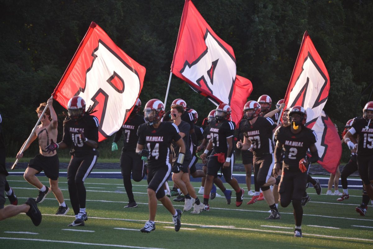 The football team and the Crimson Crazies run onto the field.