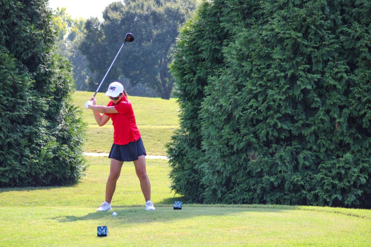 Luna Wang (9, MST) swinging her club over her head, prepared to hit the ball.