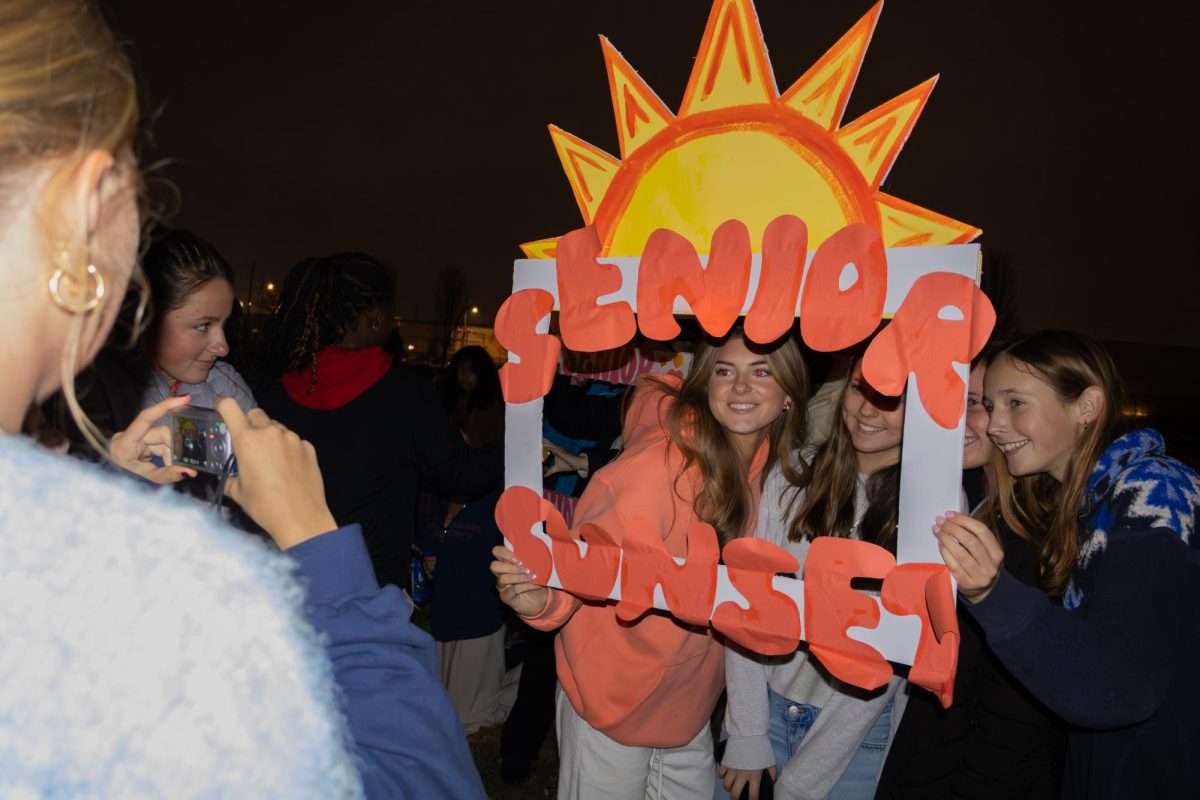Friends take pictures with custom made signs after the sunset.