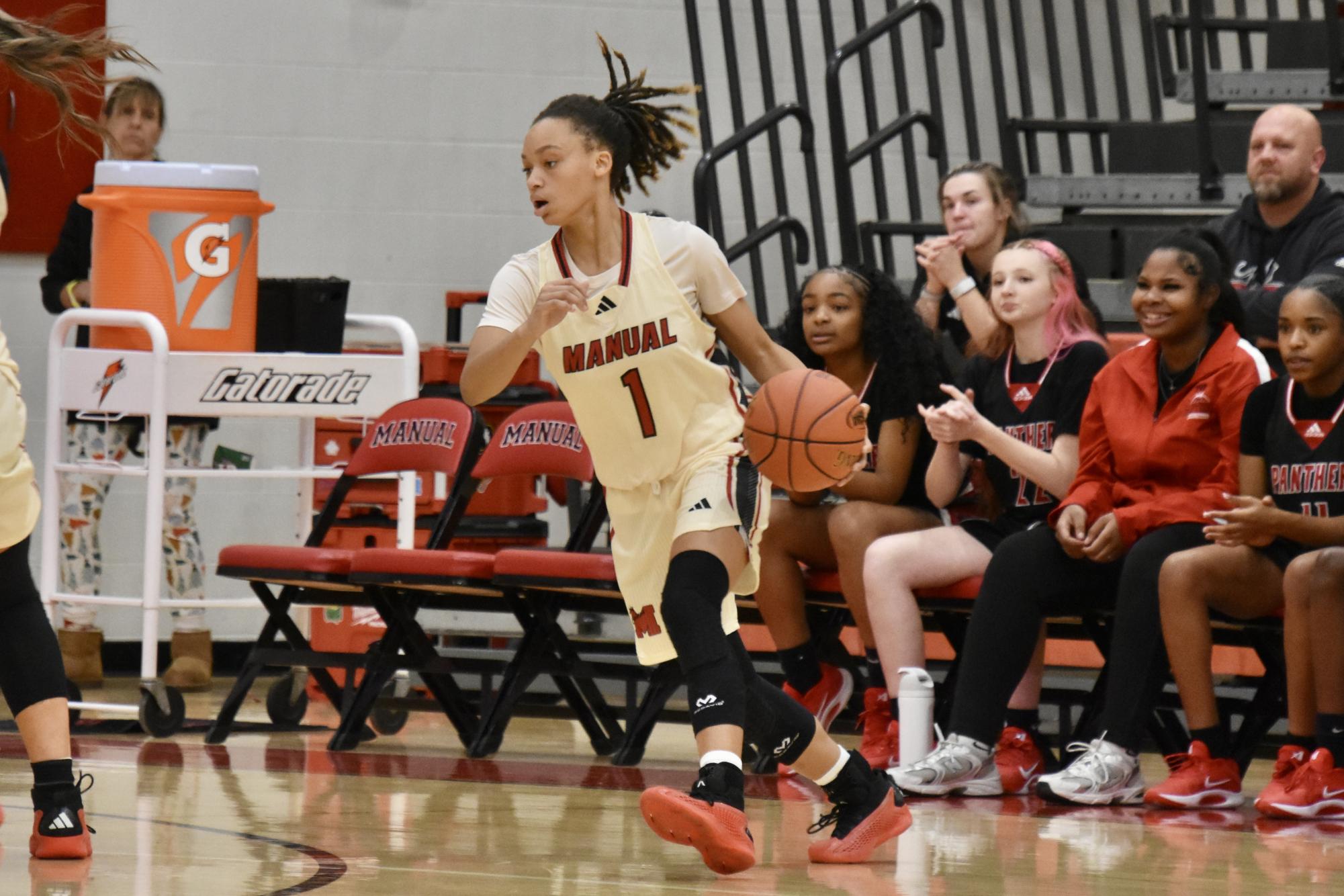 Takenzie Young (#1,10) dribbles the ball away from PRP defenders to make a shot.