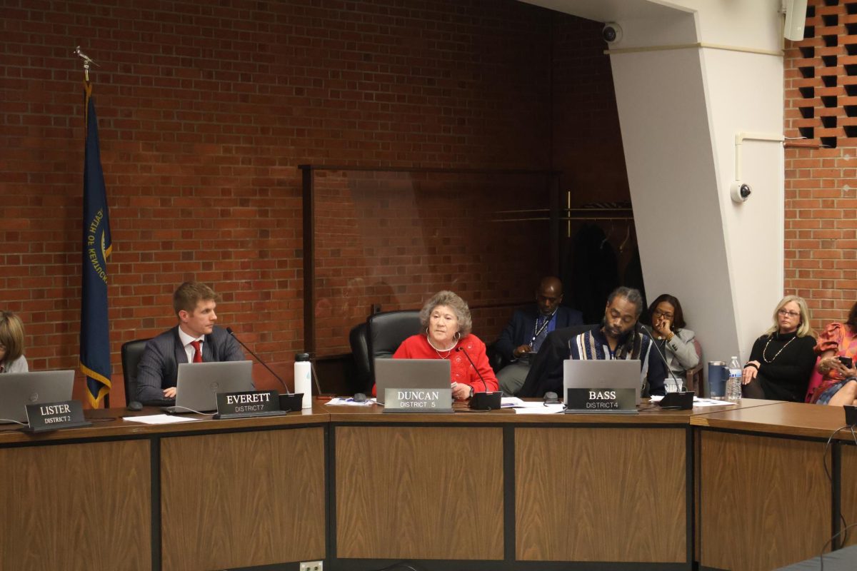 Board members Taylor Everett, Linda Duncan and Trevin Bass discuss delaying the vote on the organizational chart at the previous board meeting. 