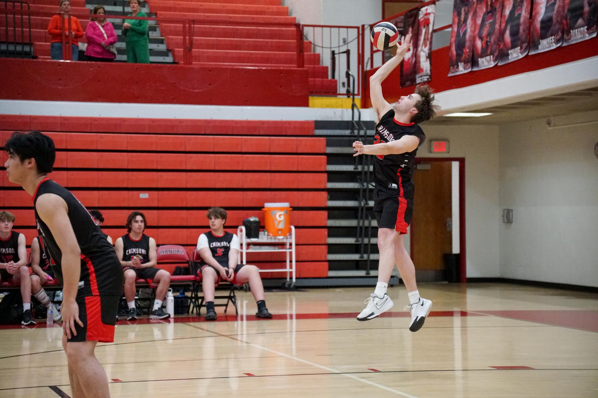 Luke Boggs (#20,12) serves the ball in the first set. 