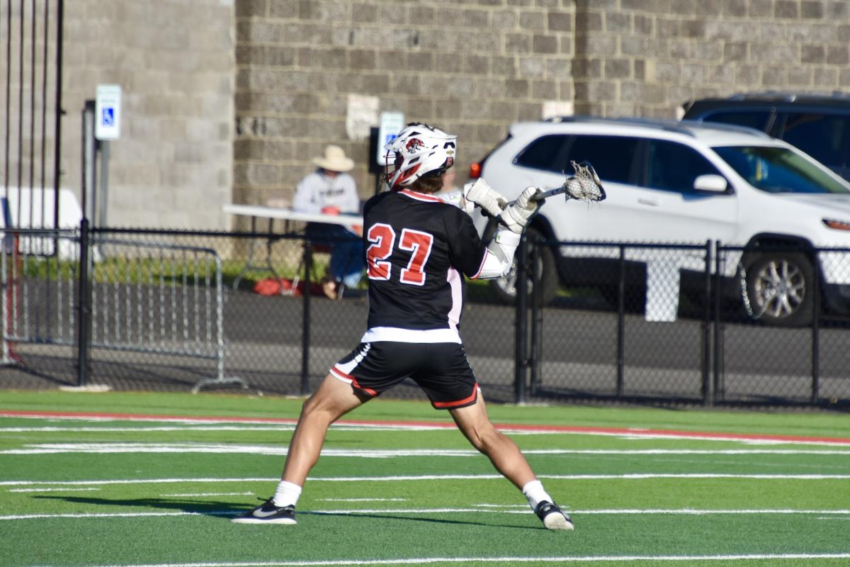 Owen Singer (#27, 11) makes a shot at the goal.