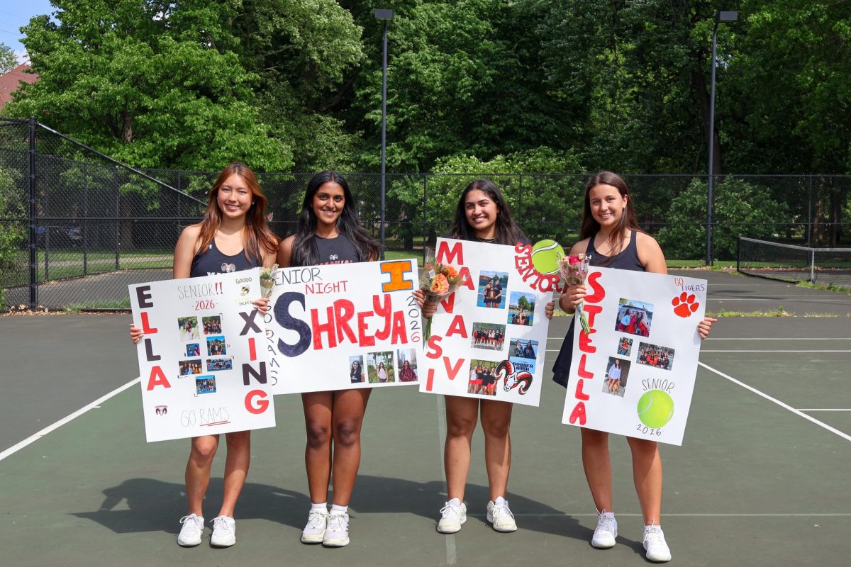 Ella Xing (12, MST), Shreya Korrapati (12, MST), Manasvi Bhavaraju (12, MST) and Stella Kolers (12, J&C) smile with signs after their senior night celebration.