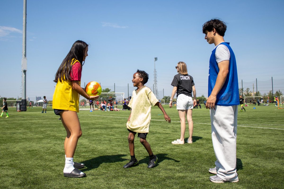 Ella Kaylor (11, HSU) and Sanad Albakri (Ballard) practice drills with a young athlete.