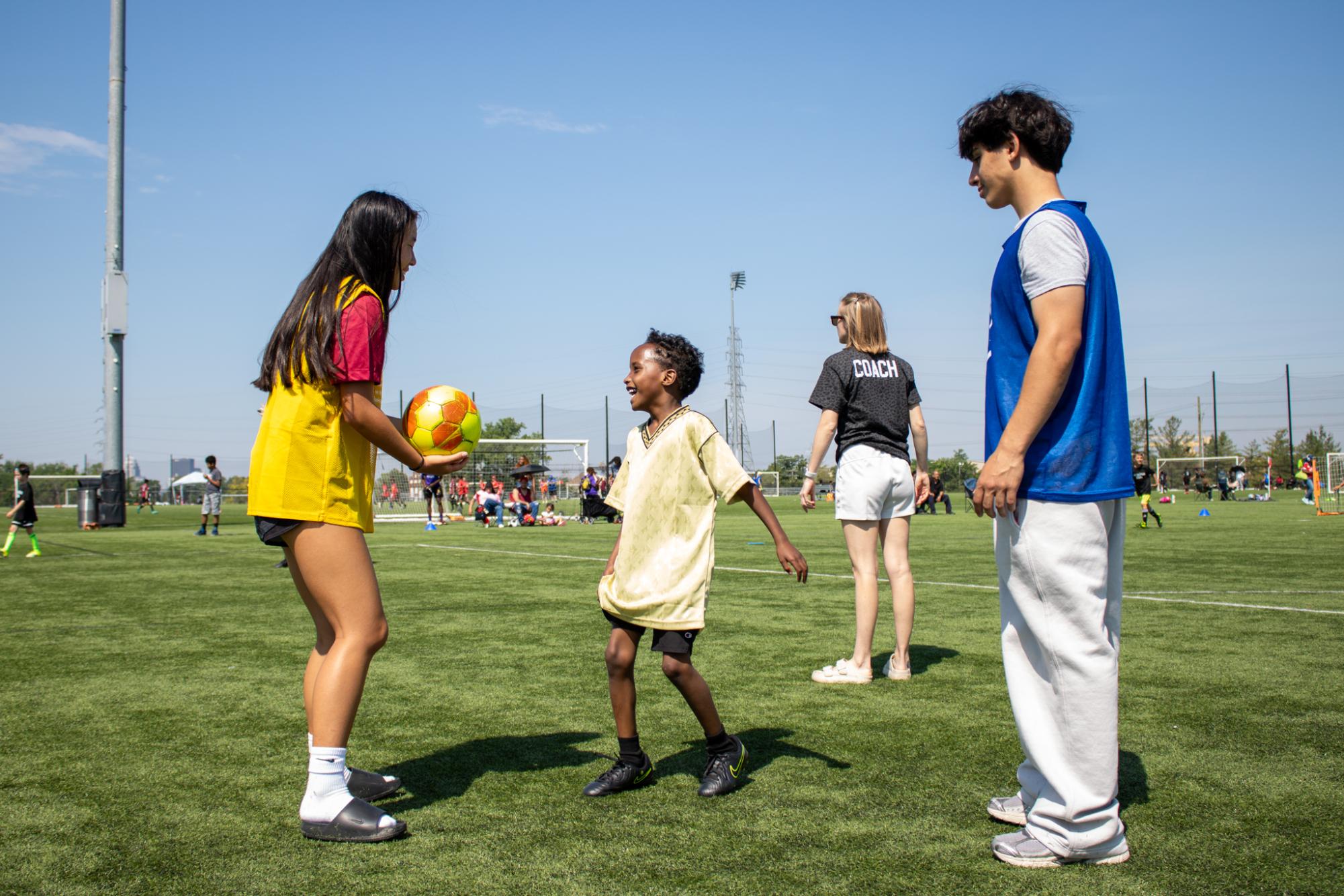 Ella Kaylor (11, HSU) and Sanad Albakri (Ballard) practice drills with a young athlete.