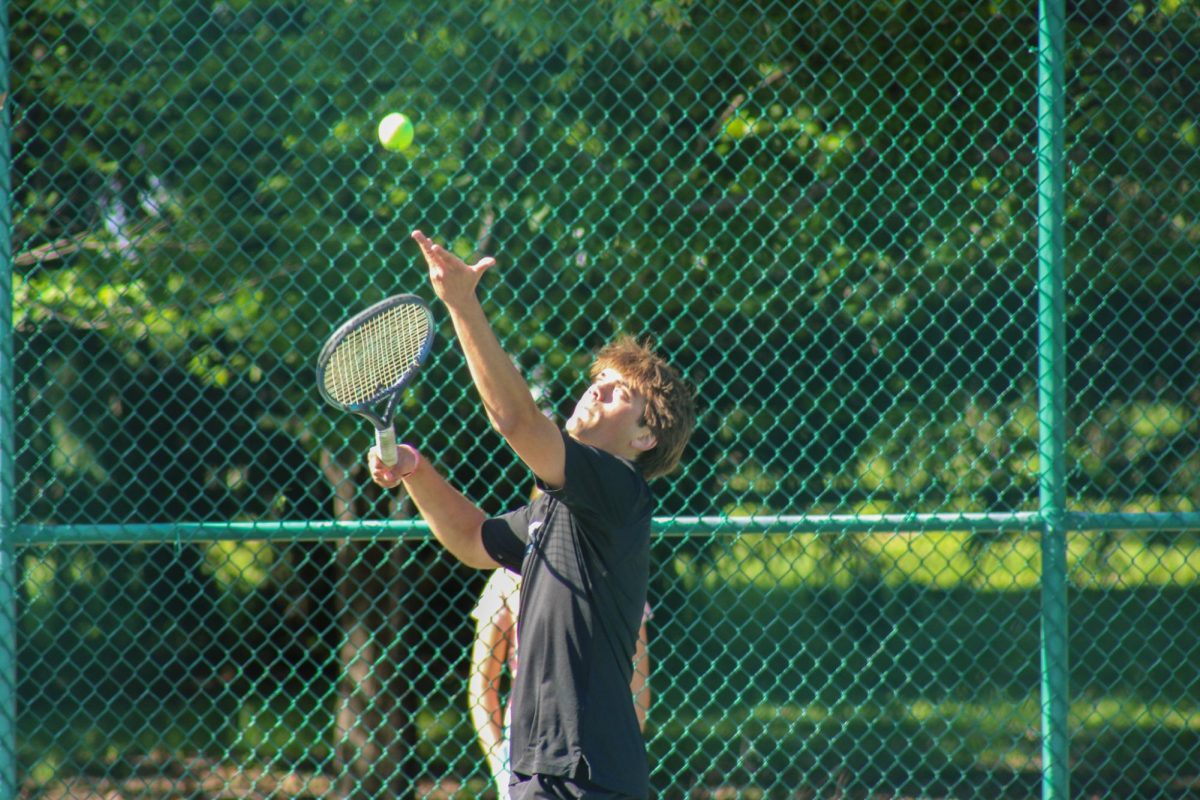 Jake Olash (12, HSU) serving the ball.